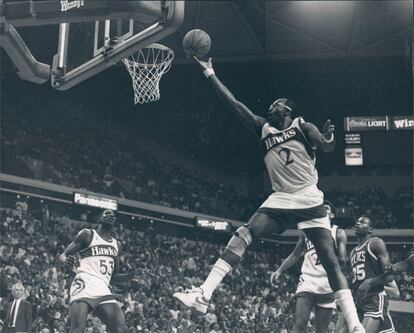 Moses Malone anota durante un partido con los Hawks.