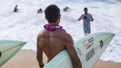 Un surfista en una playa de Ohau.