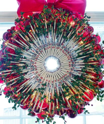Una corona navideña hecha con lápices cuelga en una ventana de la Sala Roja de la Casa Blanca, que está decorada con el lema de campaña de la primera dama Melania Trump, "Be Best" .
