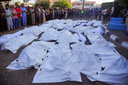 Un grupo de palestinos ante los cuerpos de sus familiares asesinados por un bombardeo israelí en la ciudad de Deir al Balah, en el centro de la franja de Gaza, este lunes.