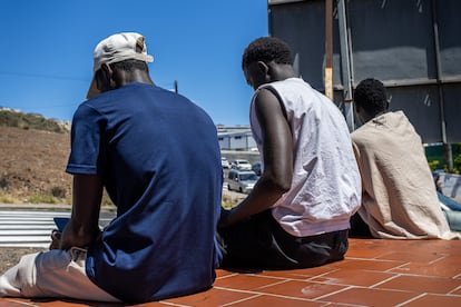 Menores que emigraron solos a Canarias pasan el día en la calle mirando sus móviles.