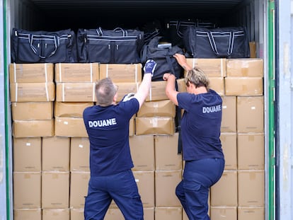 Dos agentes de aduanas buscan drogas en un contenedor el 11 de julio de 2023 en el puerto de Amberes (Bélgica).