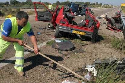 Un operario trabaja junto a los restos del accidente de esta mañana en la autovía A-52 a la altura de Mombuey, en Zamora.