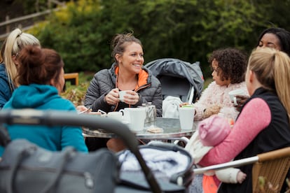 Un grupo de madres toman un café con sus hijos.