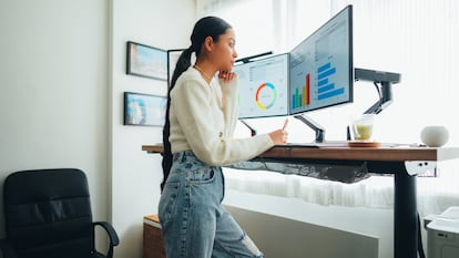 Una mujer trabajando de pie en su escritorio.