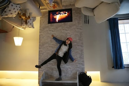 A visitor poses inside an upside-down house created by a group of Taiwanese architects at the Huashan Creative  Park in Taipei, Taiwan, Tuesday, Feb. 23, 2016. With a build price of $600,000 and over 300 square meters (3,230 square feet) of floor space filled with real home furnishings, the upside-down house will continue to be on display to visitors until July 22. (AP Photo/Wally Santana)