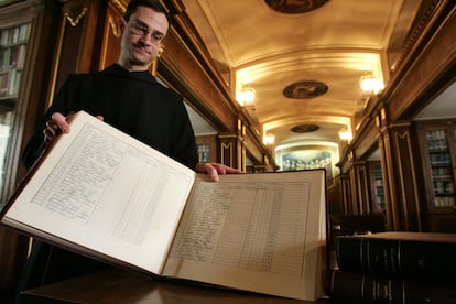 Los monjes benedictinos que custodian y velan el monumento del Valle de los Caídos conservan los libros de registro de entrada de las cajas con restos de víctimas de la Guerra Civil desde toda España entre 1958 y 1983. Alguna vez se conocían todos los datos de filiación del inhumado en las criptas, pero lo más frecuente era saber solo el nombre y apellidos del finado, la fecha de la muerte y el cementerio de donde procedía. A menudo apenas se conocía el cementerio de procedencia. En la imagen, el prior Santiago Cantera muestra uno de los libros de registros de la basílica del Valle, inventario cronológico de la llegada de los restos de muertos en la Guerra Civil.