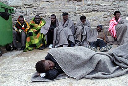 Varios inmigrantes subsaharianos descansan en el puerto de Tarifa (Cádiz) tras ser detenidos por la Guardia Civil.