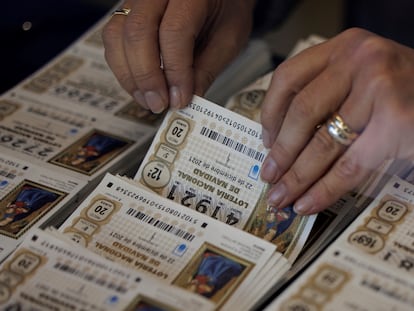 Una mujer coge un décimo del Sorteo Extraordinario de la Lotería de Navidad.