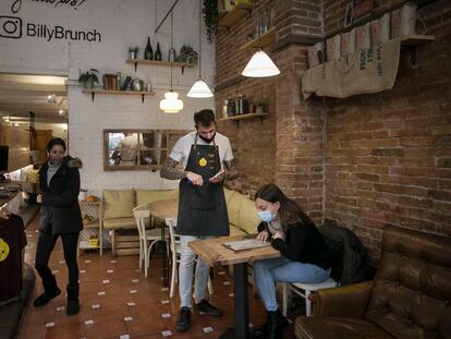 Un camarero atiende a una clienta en un bar del Eixample de Barcelona.