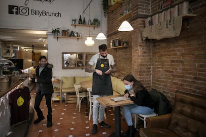 Un camarero atiende a una clienta en un bar del Eixample de Barcelona.