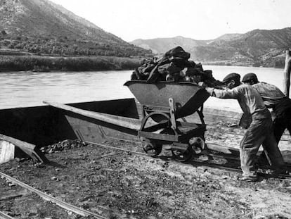 Unos trabajadores cargan un barco de carb&oacute;n en el r&iacute;o Ebro en los alrededores de Mequinenza a principios del siglo XX.