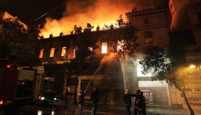 Las llamas invaden el edificio del cine Attikon, que fue incendiado durante las protestas en el centro de Atenas.