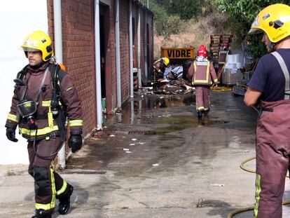 Los bomberos apagan los últimos rescoldos en la fábrica.