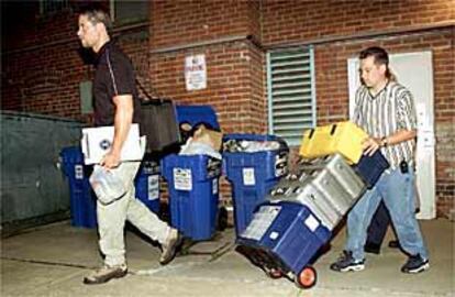 Policías de Washington salen del domicilio del congresista Gary Condit con objetos requisados.