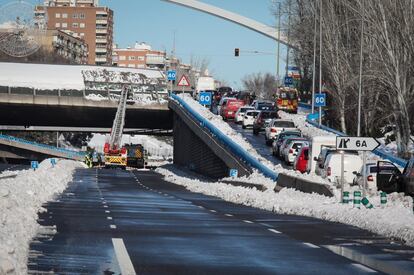 Los bomberos retiran la nieve del puente de Ventas, en Madrid.