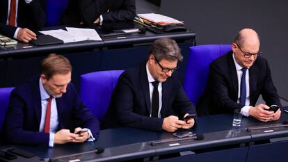 Los ministros alemanes de finanzas y economía, Christian Lindner y Robert Habeck, junto al canciller Olaf Scholz, revisan sus móviles en el Bundestag en Berlín, el pasado 13 de diciembre.