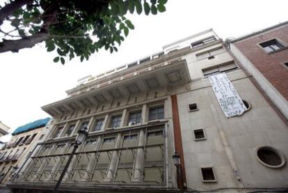 Fachada del Teatro Albéniz y del edificio anexo okupado del el que cuelga una pancarta.