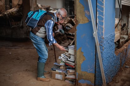 Una persona de la librería La Moixeranga de Paiporta trata de salvar, el pasado viernes, algunos libros tras los efectos de la dana