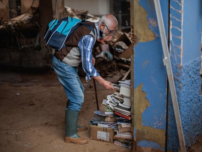 Una persona de la librería La Moixeranga de Paiporta trata de salvar, el pasado viernes, algunos libros tras los efectos de la dana
