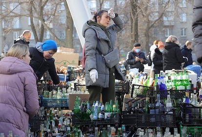 Varias personas fabrican cócteles molotov en una calle de Dnipró (Ucrania). El ministro de Asuntos Exteriores Ucrania, Dmitro Kuleba, afirmó hoy que su país no va a "capitular ni a entregar una pulga de su territorio".