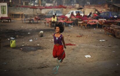 Una ni&ntilde;a juega junto a un refugio improvisado en Nueva Delhi. La pobreza en India alcanza a varios centenares de millones de personas; muchos de ellos emigran a las grandes ciudades donde, en muchas ocasiones, acaban vagando por las calles. 