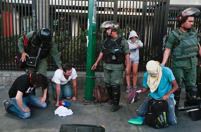 Guardias bolivarianos detienen a manifestantes, de rodillas, luego de enfrentamientos en la Plaza Altamira, el 16 de marzo de 2014.