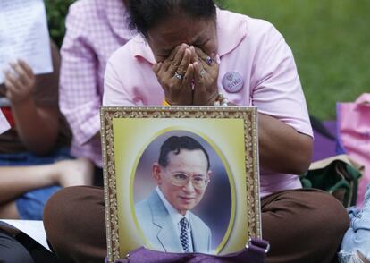 Una mujer llora delante de un retrato del rey Bhumibol Adulyadej, este miércoles 12 de octubre de 2016. EFE/Rungroj Yongrit