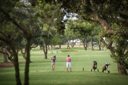 Un par de hombres y varios niños juegan al golf en el Real Club de Sotogrande.