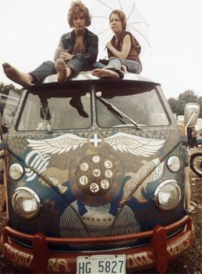 Una pareja en el techo de la mítica furgoneta Volkswagen en Woodstock en 1969.