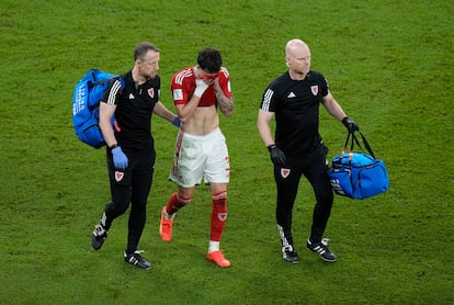 El mediocampo galés Neco Williams abandona el campo lesionado. (AP Photo/Alessandra Tarantino)