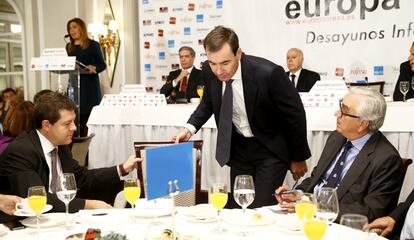 El alcalde de Toledo, Emiliano García-Page, ayuda a Tomás Gómez a mover su silla, durante la intervención de Susana Díaz (detrás), presidenta de la Junta de Andalucía, en un desayuno informativo de Europa Press en Madrid, el 29 de octubre 2014.