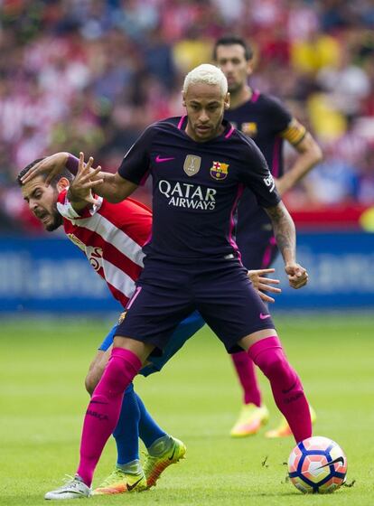 Neymar del FC Barcelona pelea por el balón junto con Víctor Rodríguez del Sporting.
