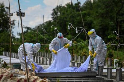 Voluntarios entierran el cuerpo de un fallecido por coronavirus en un cementerio de Yangon (Birmania). La pandemia de coronavirus ha registrado en las últimas 24 horas más de 493.000 casos nuevo en el mundo, la segunda cifra diaria más alta de toda la serie histórica, con lo que el total se eleva a más de 43,5 millones de personas contagiadas y 1,16 millones de víctimas mortales, según el balance publicado este martes por la Universidad Johns Hopkins.