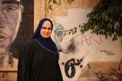 Rania Wasfi, responsable de recursos humanos y relaciones públicas del 'Freedom Theatre', junto a uno de los murales de la entrada del centro