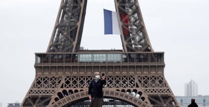 Una monja ataviada con mascarilla se toma un selfie con su teléfono móvil en la plaza del Trocadero, junto a la Torre Eiffel, este lunes en París.