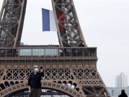 Una monja ataviada con mascarilla se toma un selfie con su teléfono móvil en la plaza del Trocadero, junto a la Torre Eiffel, este lunes en París.