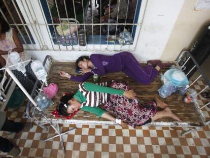 Dos trabajadoras camboyanas heridas descansan en el hospital tras el desplome de una planta de la empresa textil en la que trabajan.