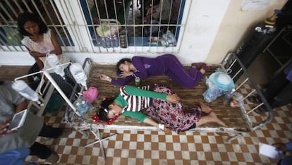 Dos trabajadoras camboyanas heridas descansan en el hospital tras el desplome de una planta de la empresa textil en la que trabajan.