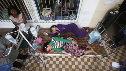 Dos trabajadoras camboyanas heridas descansan en el hospital tras el desplome de una planta de la empresa textil en la que trabajan.