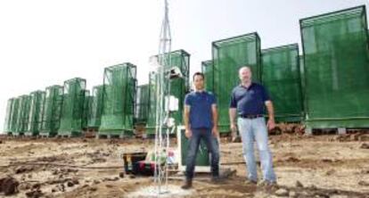 Theo Hernando (i) y Ricardo Gil (d), socios y creadores de la empresa Agua de Niebla de Canarias SL, en la finca donde tienen instalados los captadores de niebla para crear el agua. EFE/Archivo