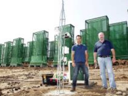 Theo Hernando (i) y Ricardo Gil (d), socios y creadores de la empresa Agua de Niebla de Canarias SL, en la finca donde tienen instalados los captadores de niebla para crear el agua. EFE/Archivo