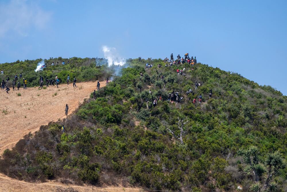 Castillejos (Morocco), 15/08/2026.- Sub-Saharan African and Sudanese migrants gather near Fnideq (Castillejos), Morocco, as they attempt to enter the Spanish city of Ceuta, 15 August 2026. Moroccan security sources said the attempted crossings took place in a mountainous area on the outskirts of Castillejos, southwest of Ceuta. (Marruecos, España) EFE/EPA/JALAL MORCHIDI
