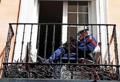 Un hombre lee en un balcón en Madrid.