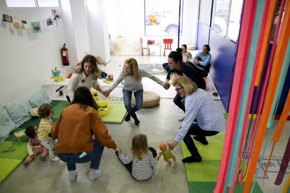  Familiares y trabajadores juegan con niños en el Centro de la Casa Grande en el barrio de Tetuán en Madrid.