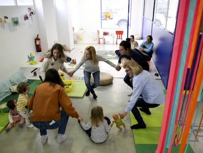  Familiares y trabajadores juegan con niños en el Centro de la Casa Grande en el barrio de Tetuán en Madrid.