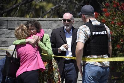 Dos mujeres se abrazan en el exterior de la sinagoga Chabad, en Poway, California.