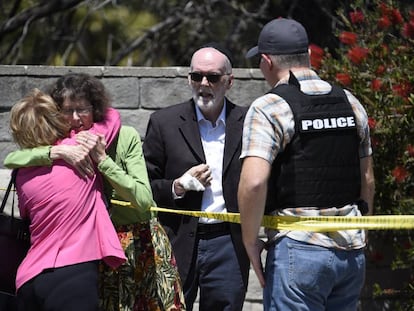 Dos mujeres se abrazan en el exterior de la sinagoga Chabad, en Poway, California.