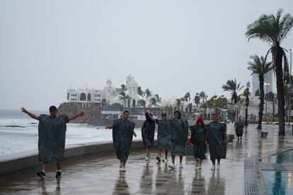 Un grupo de turistas camina por un malecón en Mazatlán, antes de la llegada de 'Orlene' a las costas del Pacífico mexicano.
