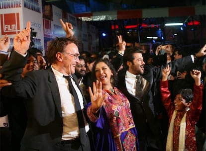 Danny Boyle, a la izquierda, codirector de <i>Slumdog millionaire,</i> baila el jueves en la alfombra roja con los actores Shabana Azmi y Anil Kapoor.